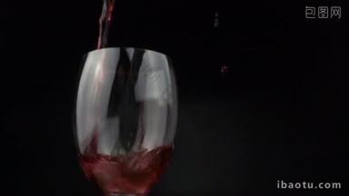 在慢动作中, 将红酒倒在黑色背景上的葡萄酒杯上